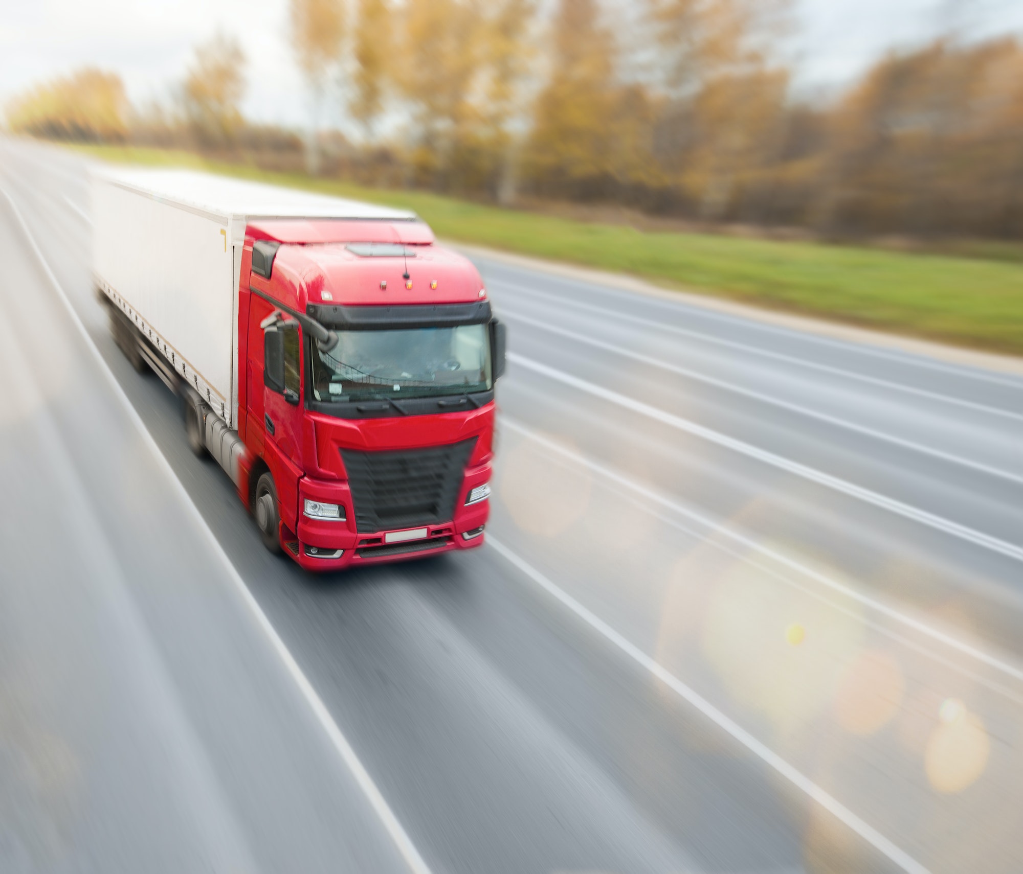 Red heavy truck driving on the highway